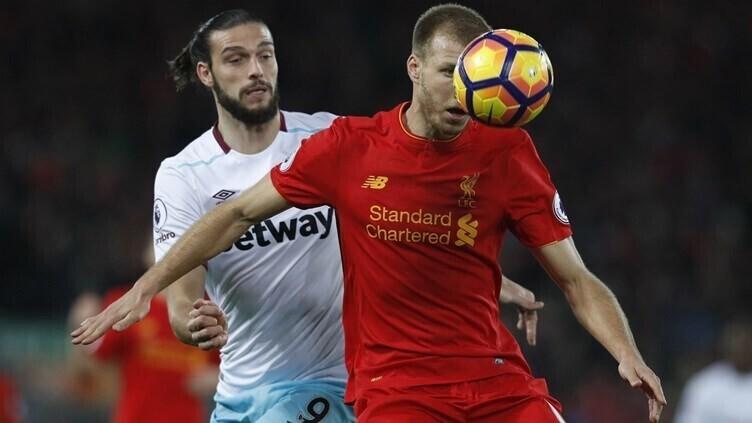 Рагнар Клаван (в красном) принимает мяч.