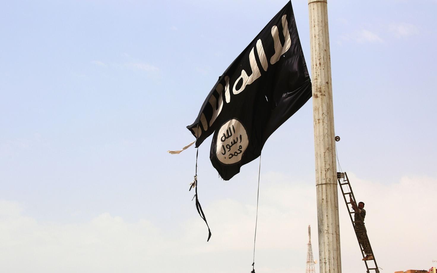 Süüria Demokraatlike Jõudude (SDF) liige langetamas Tabqas ISIS-e lippu.