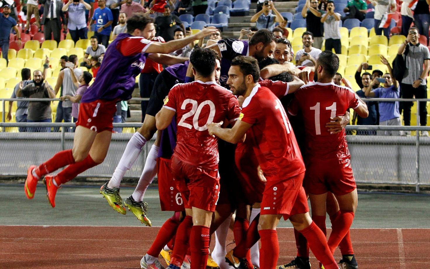 Сирийские футболисты празднуют гол нападающего Омара Аль-Сома.