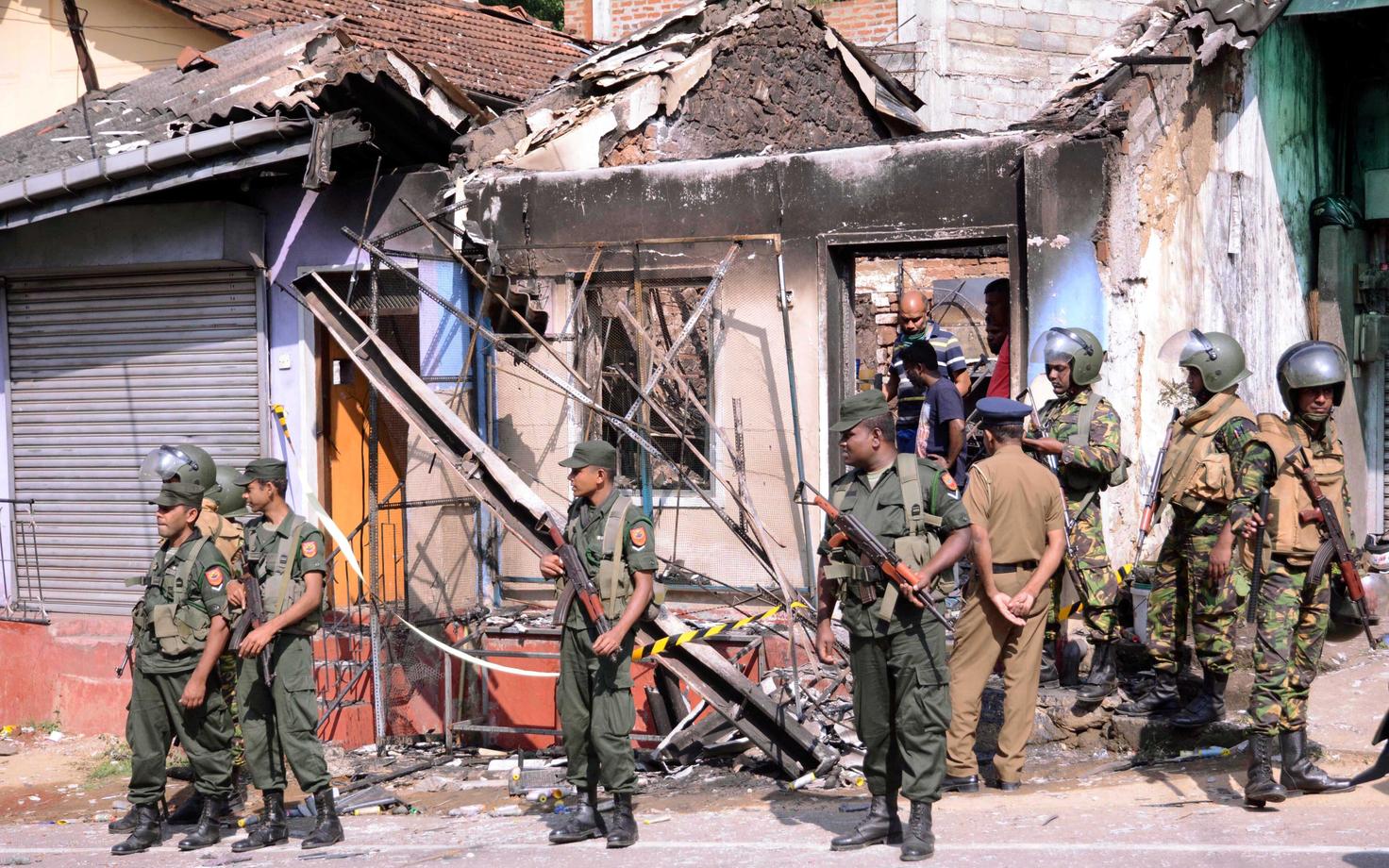 Sri Lanka eriüksuslased Kandy regioonis Diganas kokkupõrgete käigus põlema pandud hoone ees.