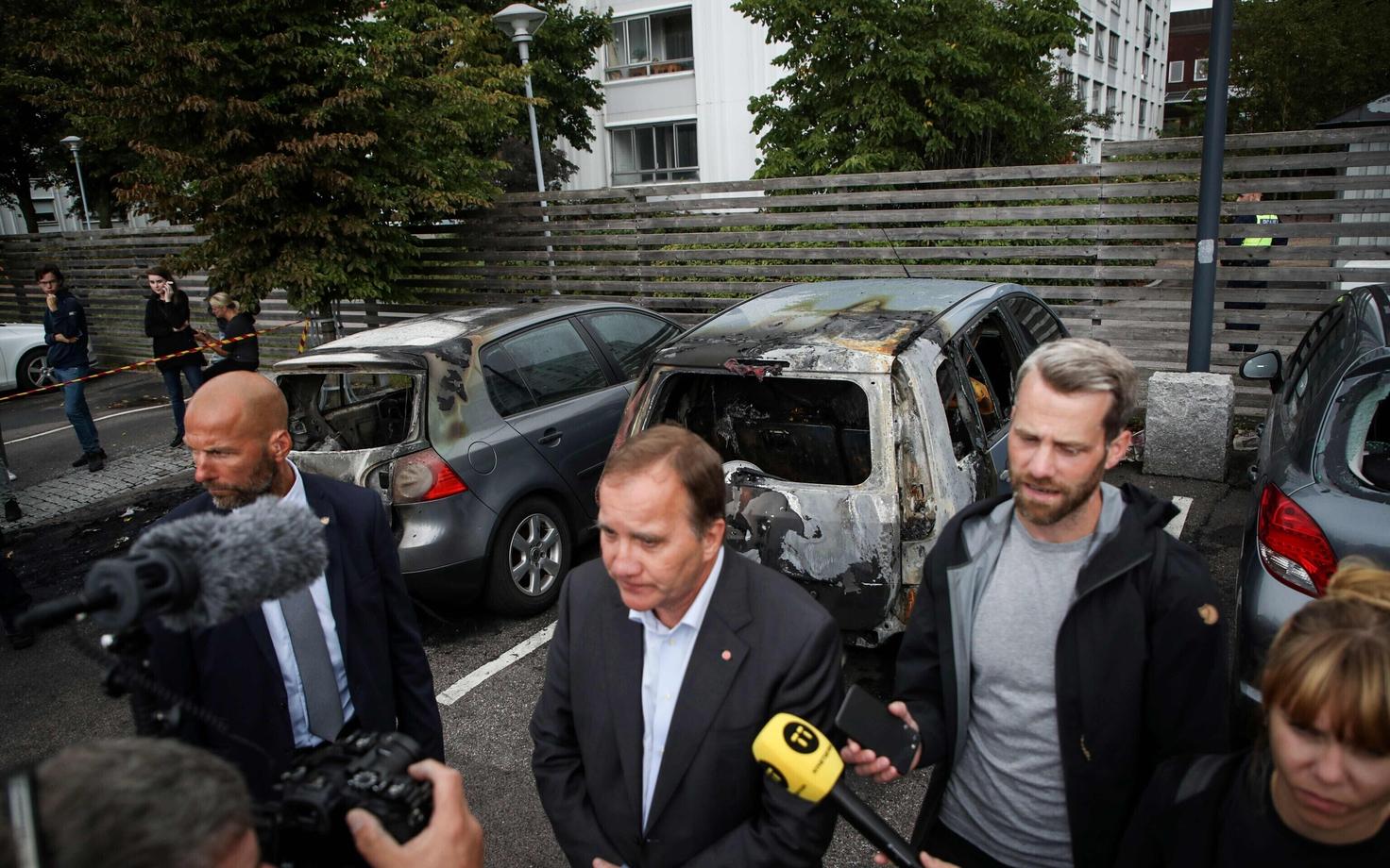 Rootsi peaminister Stefan Löfven räägib ajakirjanikega põlenud autode juures Göteborgis.
