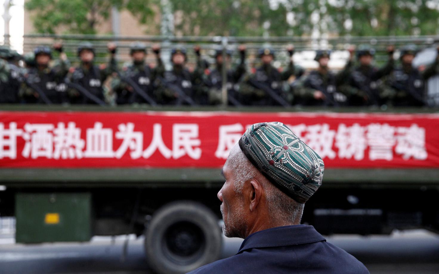 Uiguuri mees vaatamas Urumqis Hiina sõjaväekolonni 2013. aastal.