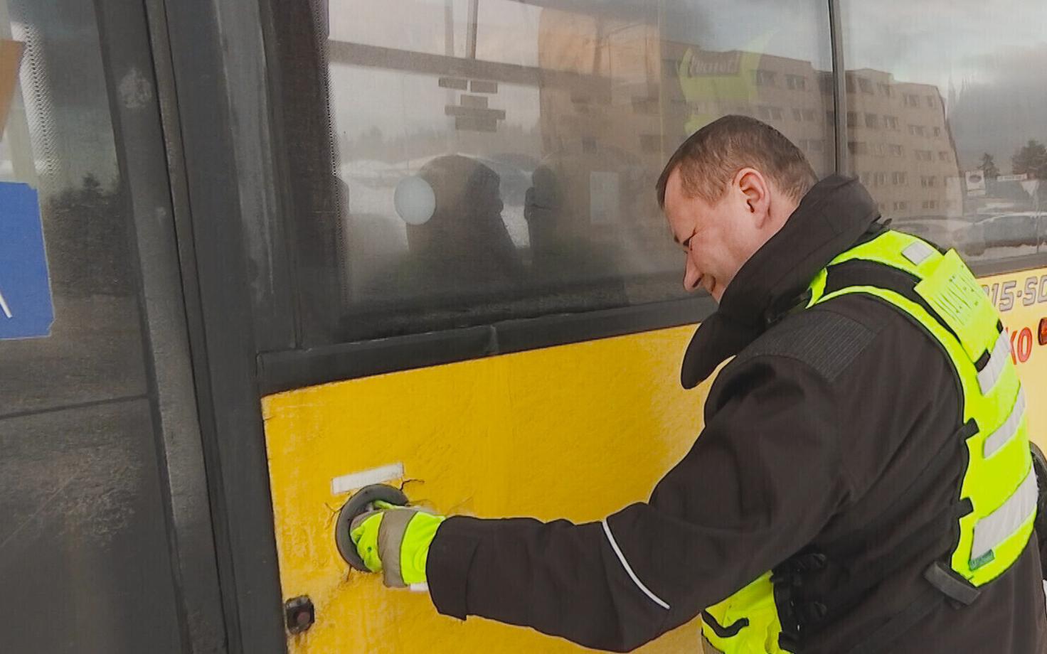 Police officer inspecting an Atko bus.