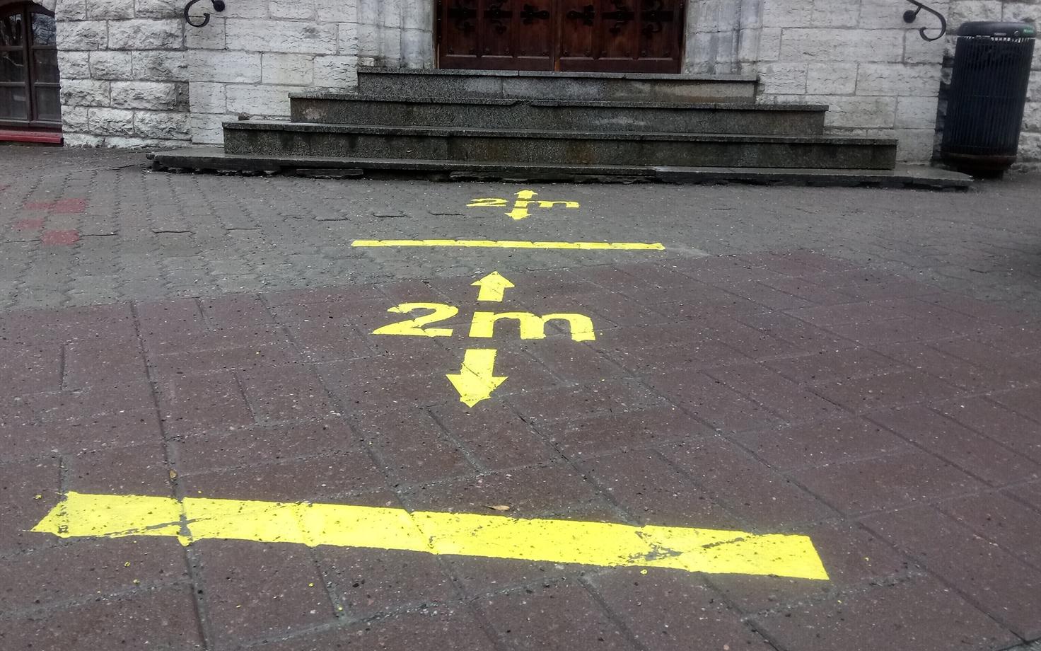 Painted 2-meter distance markers on a Tallinn sidewalk.