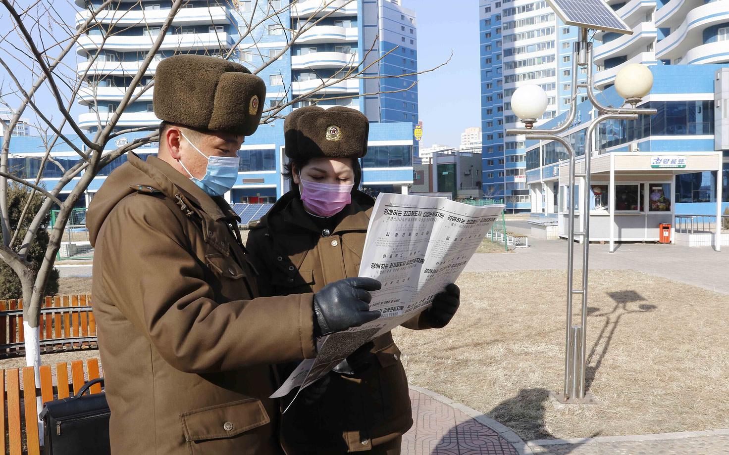 Korrakaitsjad Pyongyangi tänaval Kim Jong-uni uusaastatervitust lugemas