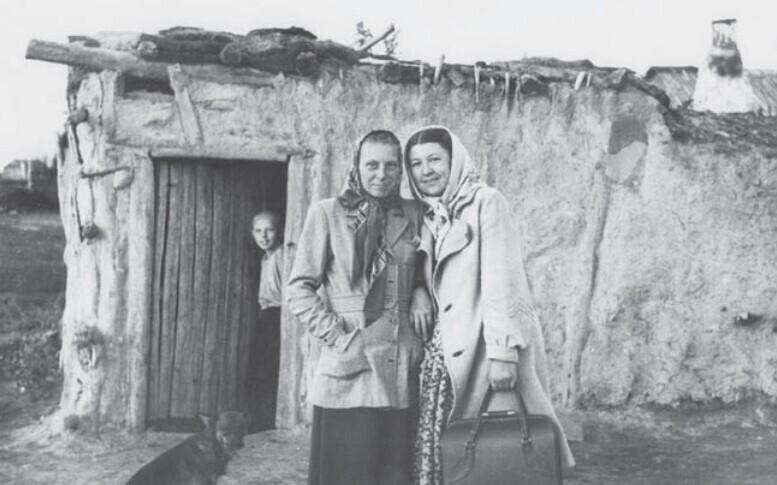 Küüditatud eestlased Siberis savist ja sõnnikust ehitatud onni taustal.