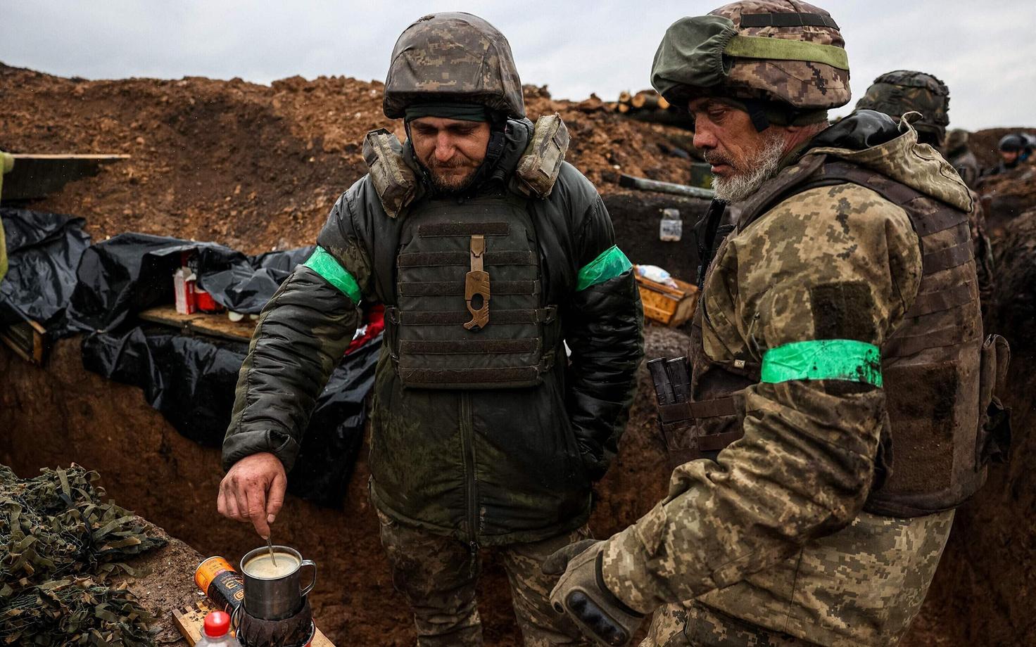 Украинские солдаты из 57-й мотопехотной бригады пьют кофе в окопе под Бахмутом.