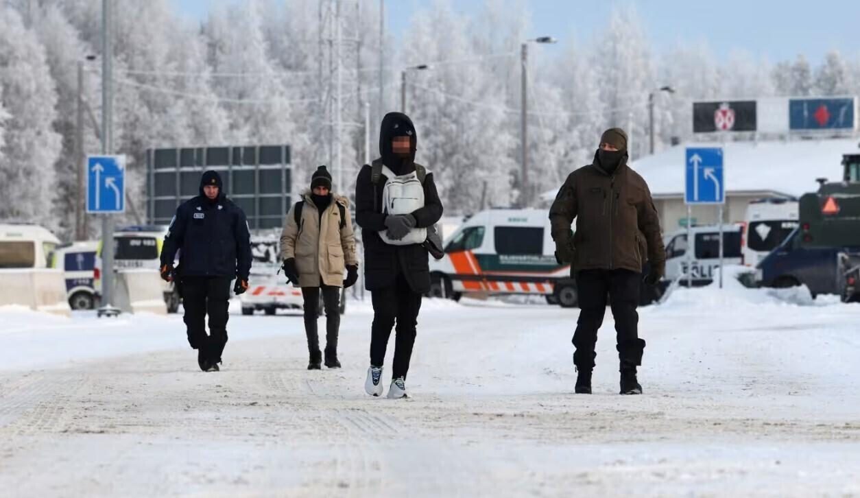 Vartiuse piiripunkti jõudnud migrandid ja neid saatvad piirivalvurid.