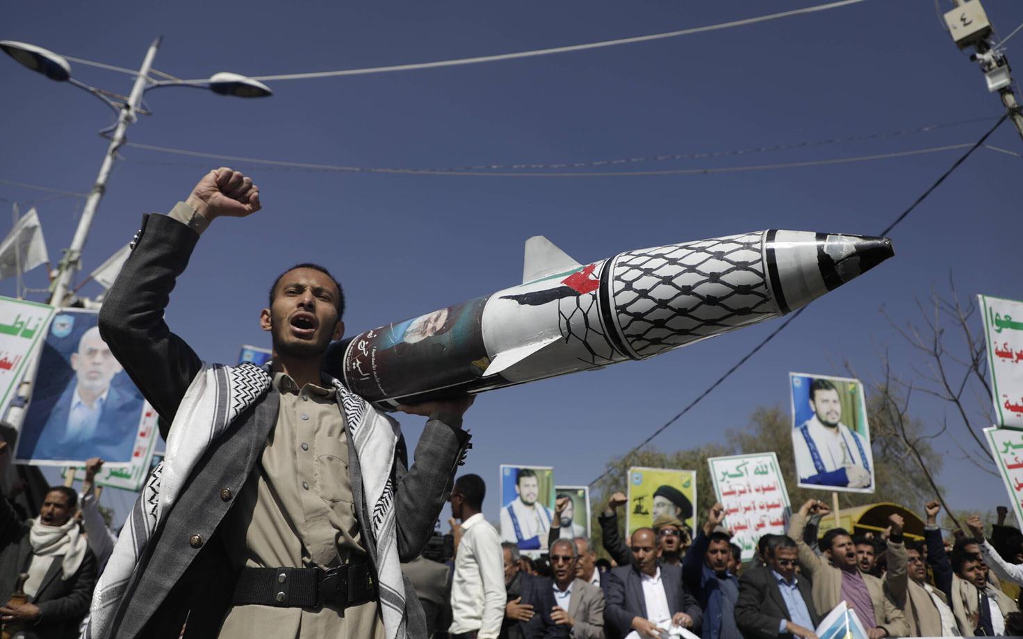 Митингующий в Сане с макетом ракеты.