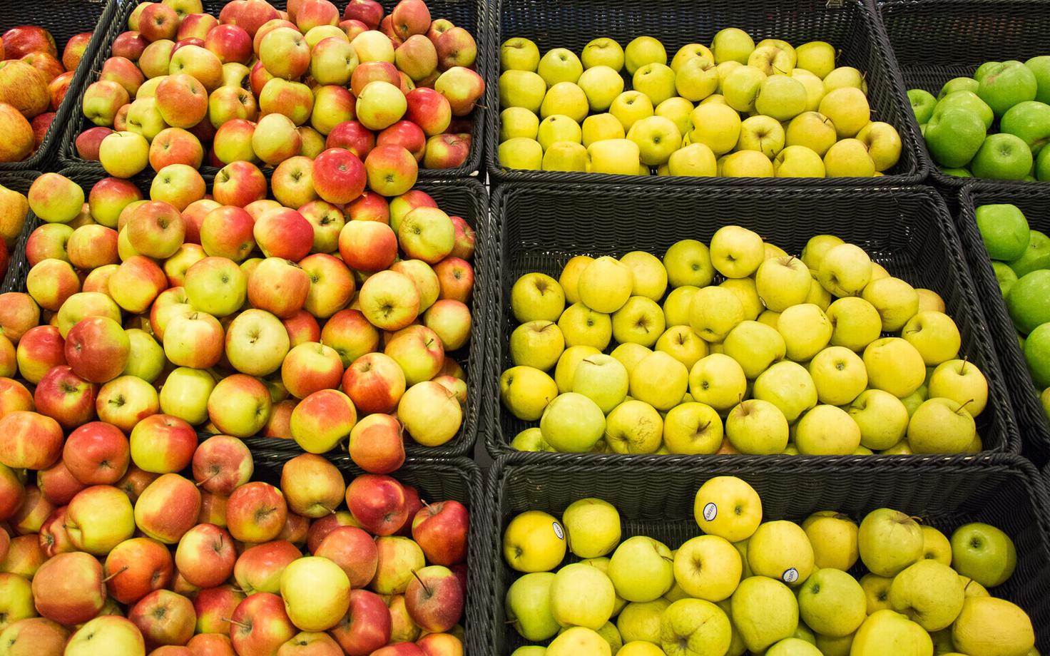 Fresh apples for sale in a supermarket, many of which are imported.