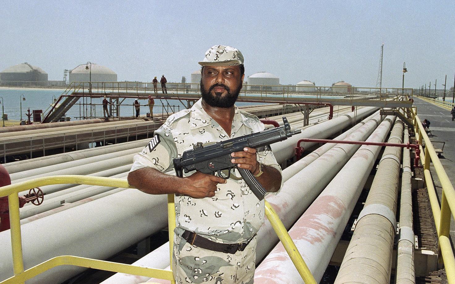 Охранник саудовской нефтяной компании Aramco охраняет трубопроводы предприятия.