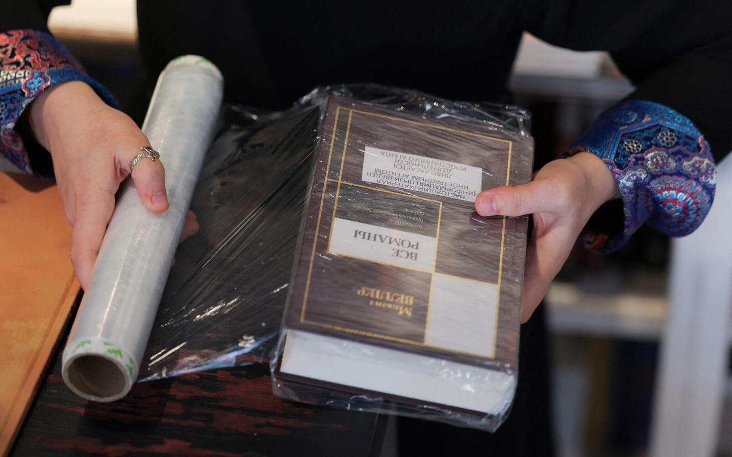 Töötaja märgistab ja kiletab raamatut, mille on kirjutanud „välisagendiks“ kuulutatud Mihhail Veller